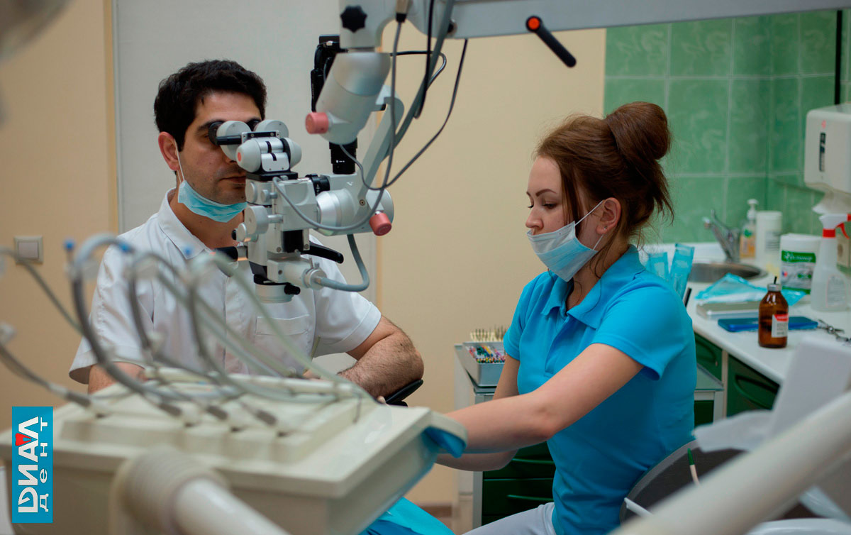 стоматолог-эндодонтист проводит лечение каналов зубов с микроскопом