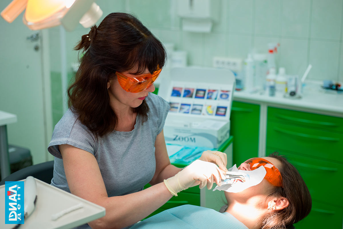 специалист по отбеливанию зубов наносит защитный слой на слизистую рта